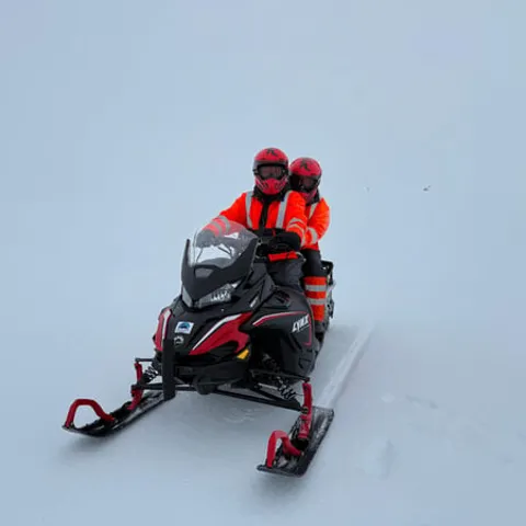 Two riders on a snowmobile on the ice cap
