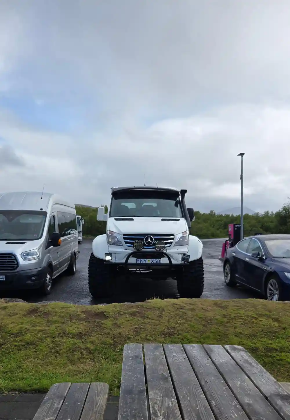 Multiple white vans and large truck parked together