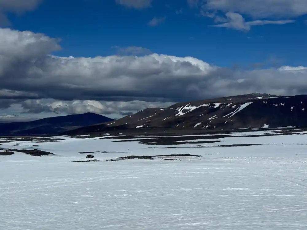 Snow-covered plain with distant dark mountains