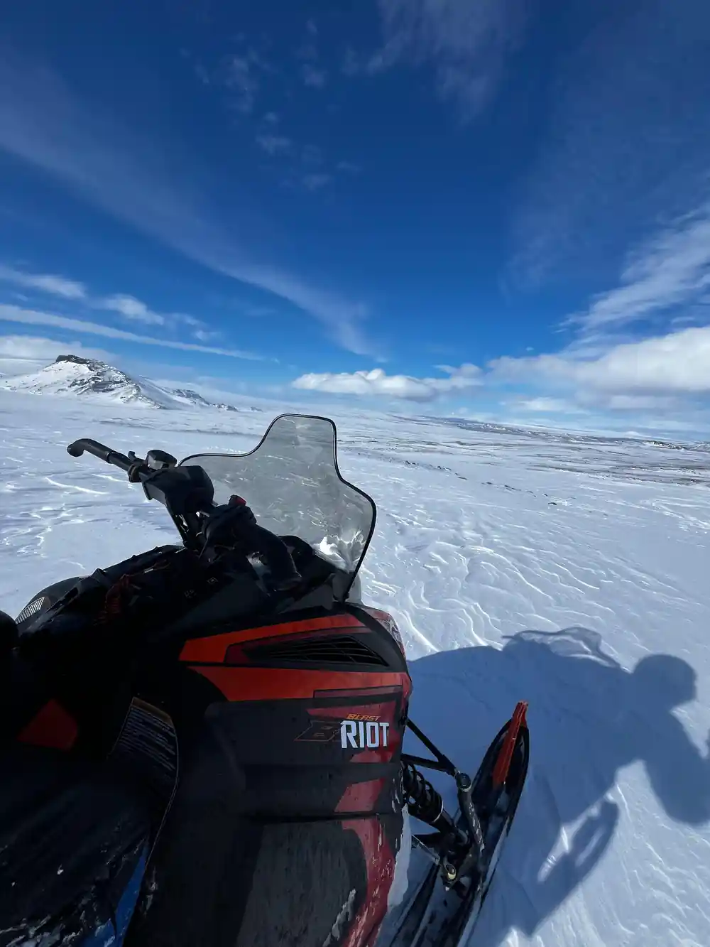 Snowmobile on snowy landscape under blue sky