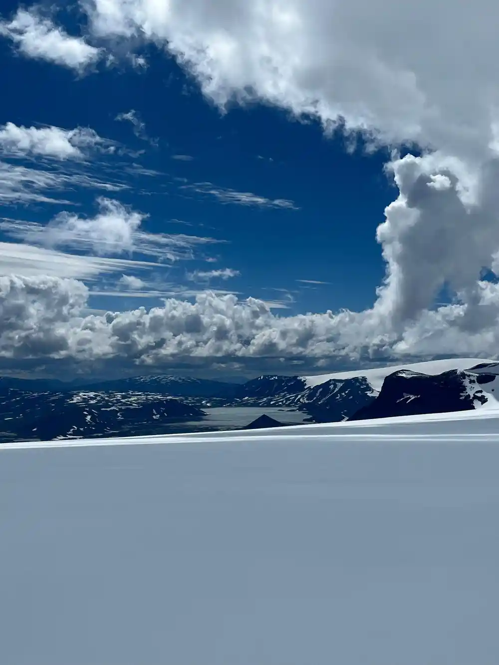 Snowy landscape with mountains and dramatic cloudy sky