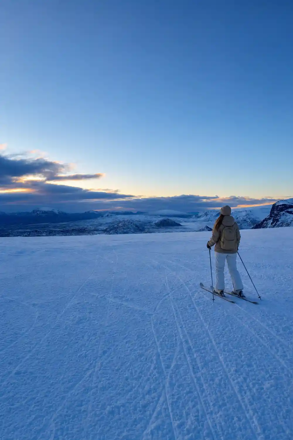 Vast frozen lake landscape at dusk with mountains