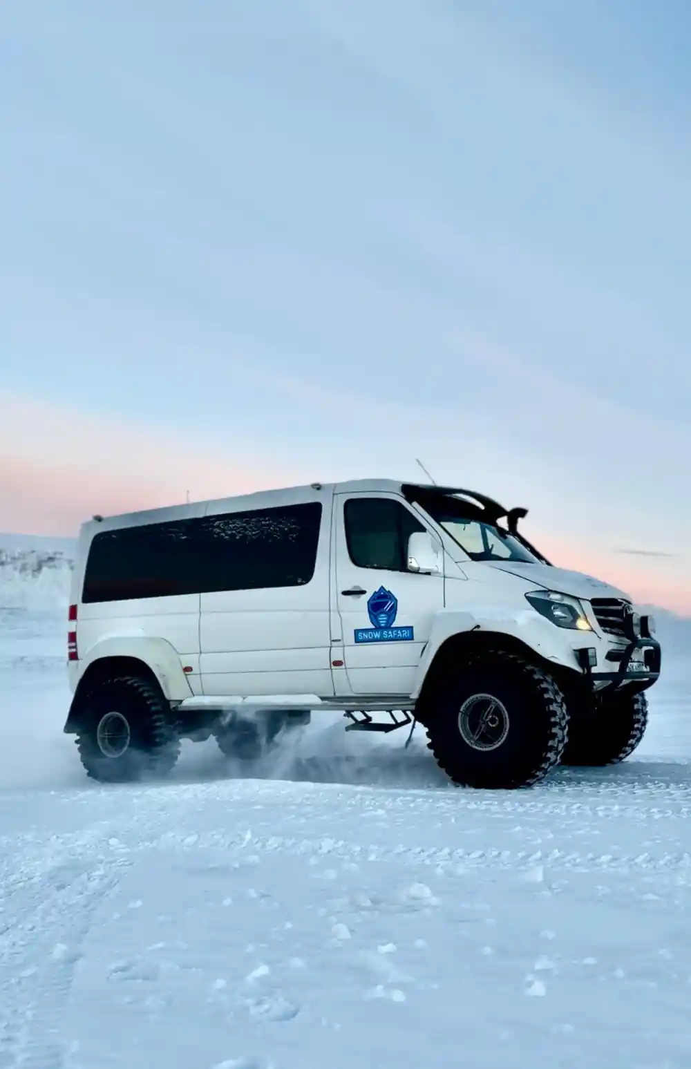 White van with winter tires on snowy landscape